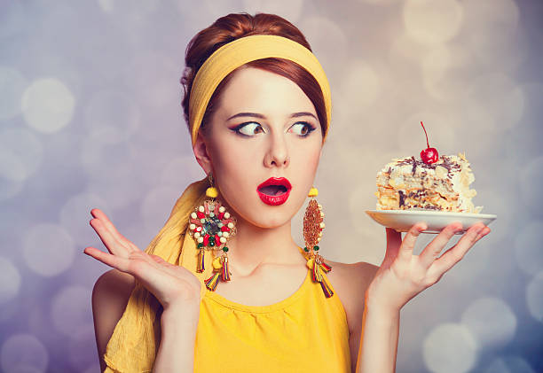 Style redhead girl with cake. Style redhead girl with cake. Photo with bokeh at background. Models EATING stock pictures, royalty-free photos & images