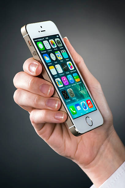 holding iphone 5s - iphone human hand iphone 5 smart phone стоковые фото и изображения