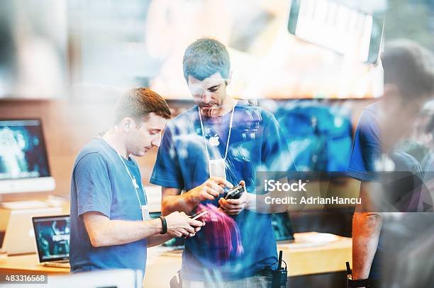 Apple Store Interior Reflected With Customers Waiting In Line Outside Stock Photo - Download Image Now