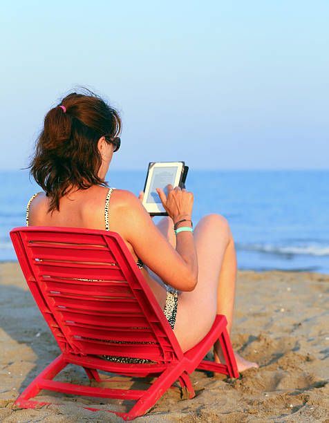 istock woman reads the ebook on the beach 483316994
