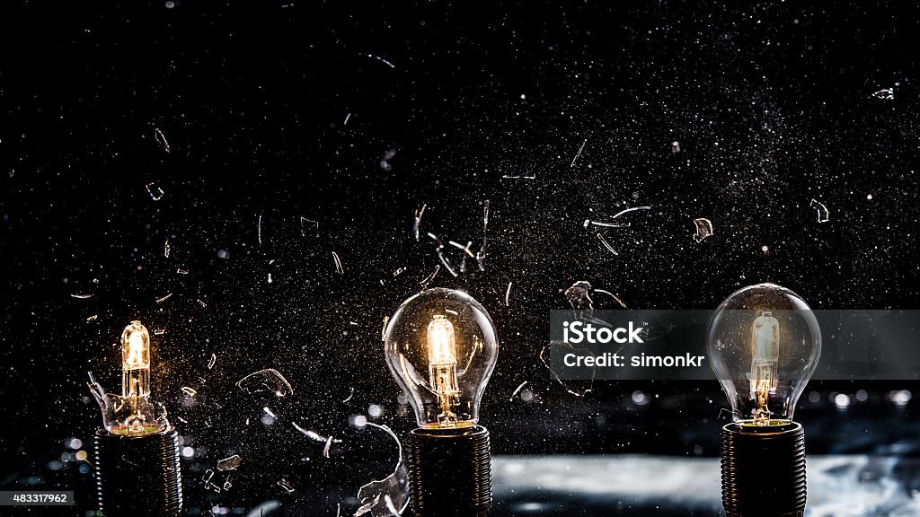 Light bulbs exploding Light bulbs exploding in a line against black background, close-up. Light Bulb Stock Photo