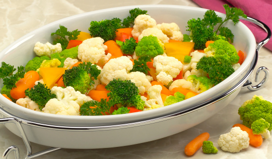 Broccoli, cauliflower, carrots, parsley and orange peppers in formal serving dish