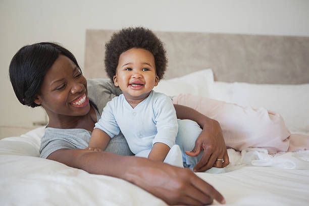 istock Happy mother with cute baby relaxing in bed 483320267