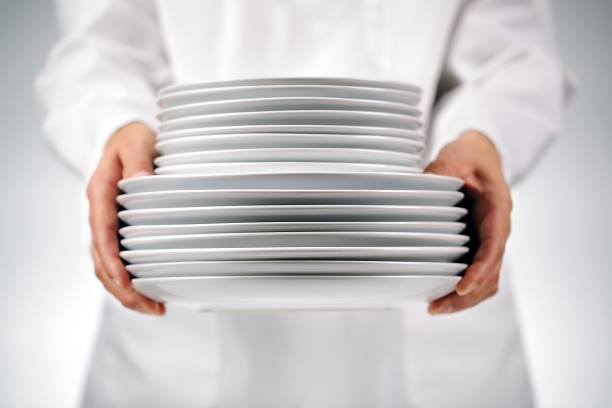 Holding plates Chef or waitress holding plates in a restaurant kitchen white restaurant dishes stock pictures, royalty-free photos & images