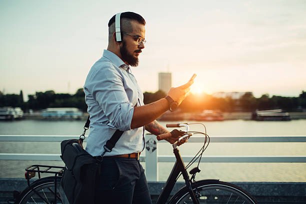 biznesmen naciśnij rowerze i przy użyciu smartphone na zewnątrz. - headphones music mobile phone tattoo zdjęcia i obrazy z banku zdjęć