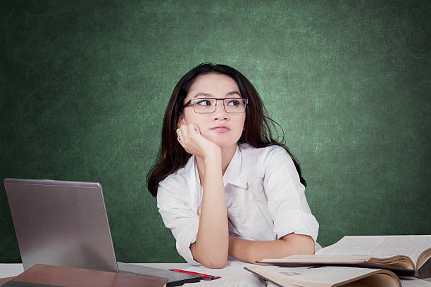 istock Student daydreaming in class with books and laptop 483332548