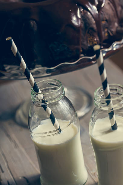pastel bundt y dos botellas de leche con popotes - milk milk bottle drinking straw cookie fotografías e imágenes de stock