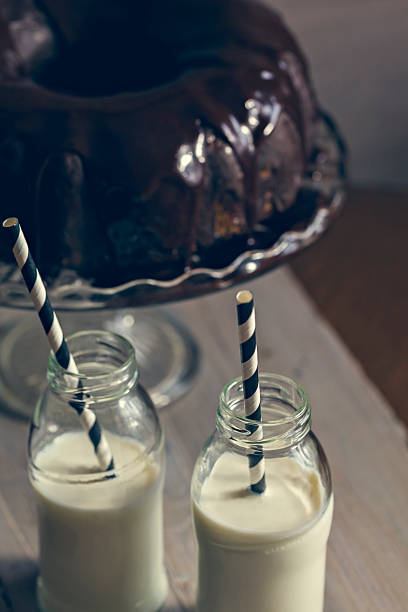 pastel bundt y dos botellas de leche con popotes - milk milk bottle drinking straw cookie fotografías e imágenes de stock