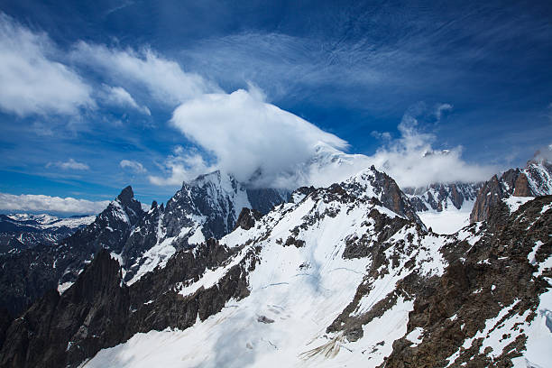 View of clouded Mont Blanc peak and Aiguille Noire de Peuterey peak in the background from Punta Helbronner cable car station, Mont Blanc massif, Italy