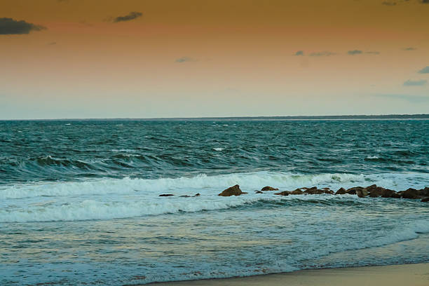 Caloundra Waves A beautiful sunset over the Pacific waves at Caloundra, Queensland, Australia. caloundra stock pictures, royalty-free photos & images