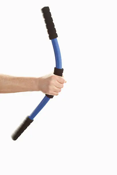 Mature man holding swingstick against white background