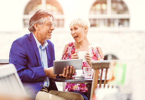 istock Cheerful adult couple at the coffee bar using digital tablet 483339366