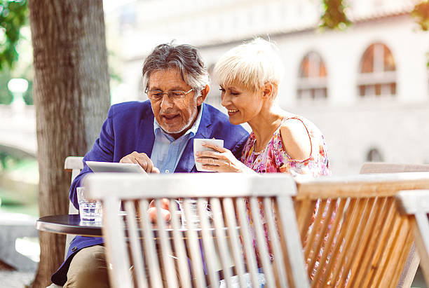 istock Cheerful adult couple at the coffee bar using digital tablet 483339390
