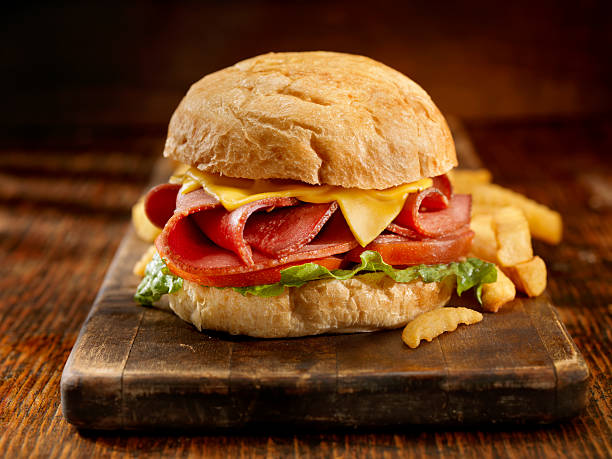 Fried Bologna Sandwich with Fries Fried Bologna Sandwich with Lettuce, Tomato, Melted Cheese and Fries-Photographed on Hasselblad H3D2-39mb Camera baloney photos stock pictures, royalty-free photos & images