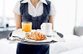 Room service hotel staff carries breakfast tray