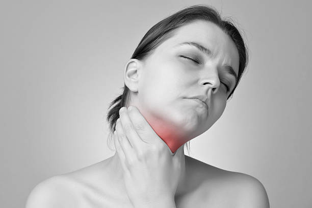 Throat pain Young woman holding her painful throat neck photos stock pictures, royalty-free photos & images