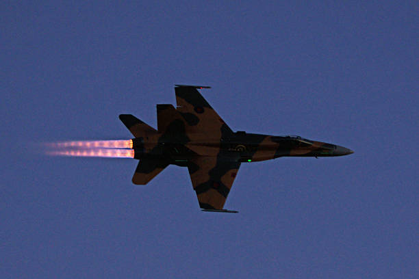 f - 18 hornet jet fighter fliegen durch nachthimmel - vapor trail sky night sunset stock-fotos und bilder