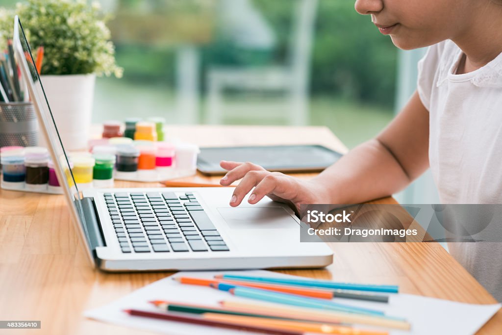 Using laptop Cropped image of little girl using laptop at home Creativity Stock Photo