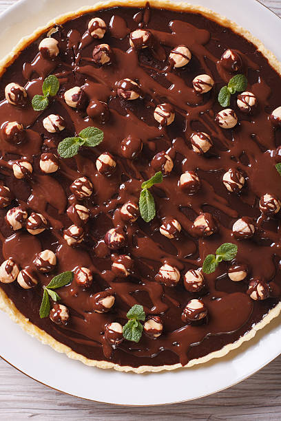 istock Chocolate tart with hazelnut close-up. vertical top view 483359894
