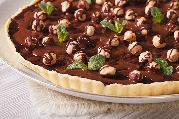 istock Chocolate tart with hazelnut and mint close-up. Horizontal 483359896