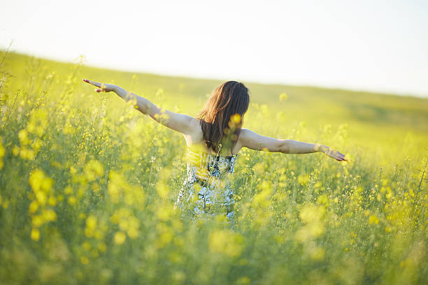istock girl stands on rapeseed field 483360164