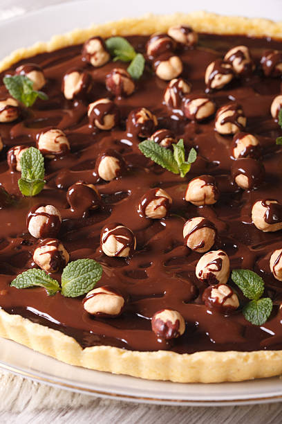 istock tart with chocolate and hazelnuts on a table closeup. Vertical 483362266