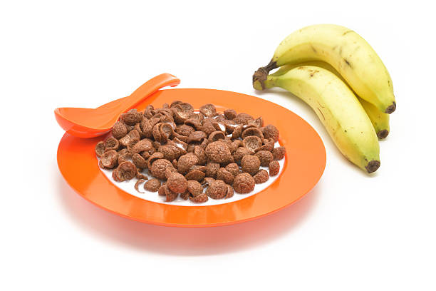 Isolated cereal on orange dish and bananas Isolated cereal on orange dish and bananas cerial stock pictures, royalty-free photos & images