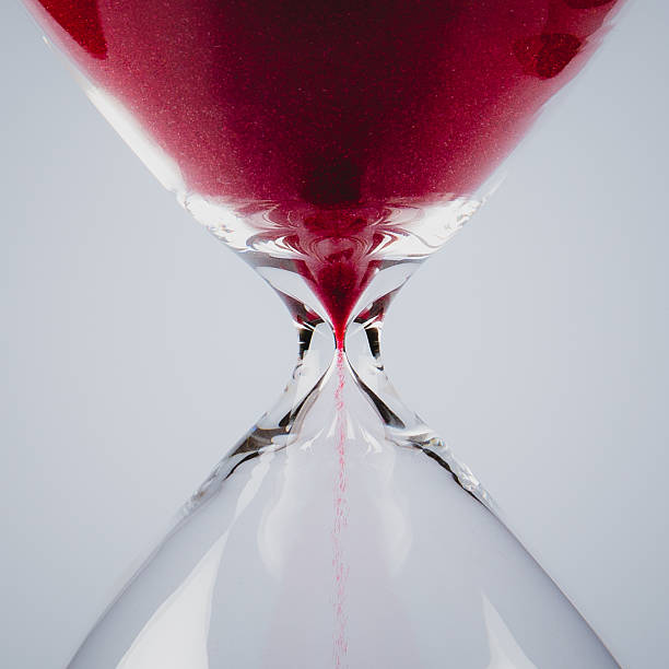 Red sand in an hourglass, square Red sand falling down in an hourglass, square hourglass photos stock pictures, royalty-free photos & images