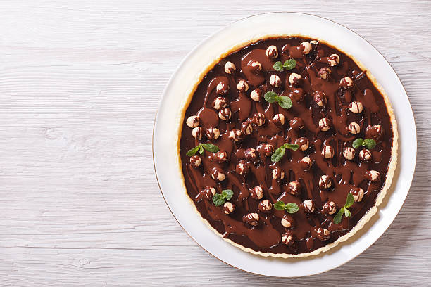 Chocolate tart with hazelnut on a plate horizontal top view