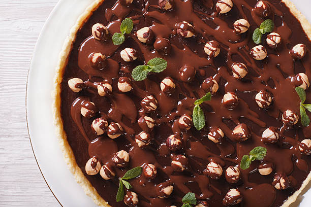 istock Chocolate tart with hazelnut close-up. horizontal top view 483363530