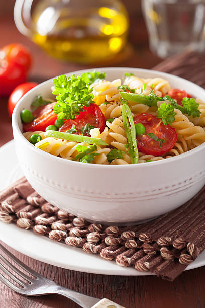 istock vegetarian pasta fusilli with tomato peas herbs 483367238