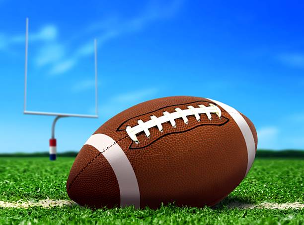 футбольный мяч на траве на голубое небо - football lineman стоковые фото и изображения