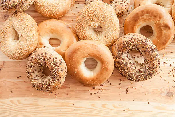 Variety of fresh bagels on rustic wooden background