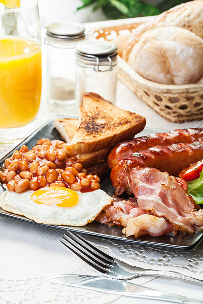istock Full English breakfast with bacon, sausage, egg, baked beans and 483371346