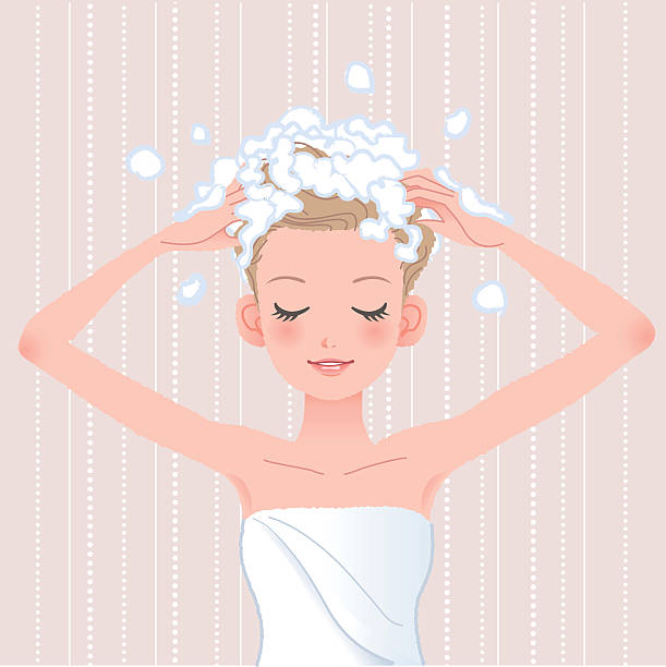 молодая женщина стиральная ее головы с шампунем - wrapped in a towel illustrations stock illustrations