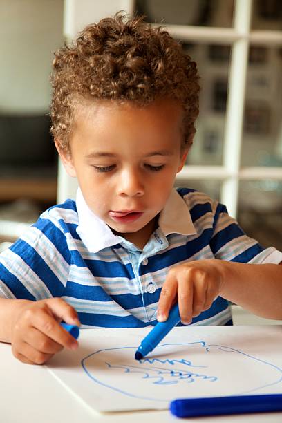 istock Adorable Little Boy Draws with Crayons 483371399