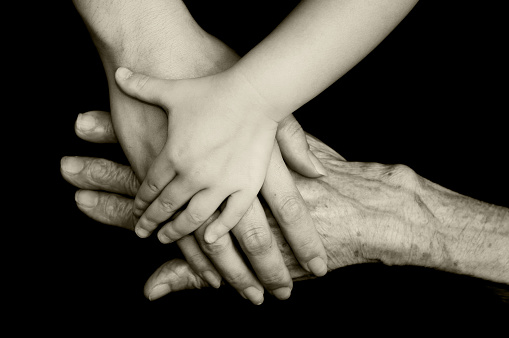 hands of three generations on top of one another. 
