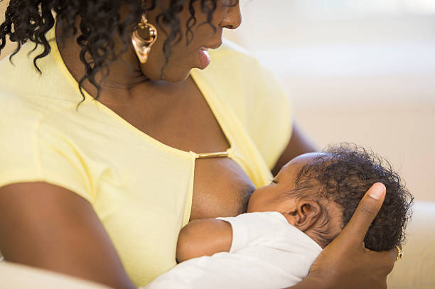 Mother cuddling with her baby Mother cuddling with her newborn baby in the living room unknown gender stock pictures, royalty-free photos & images