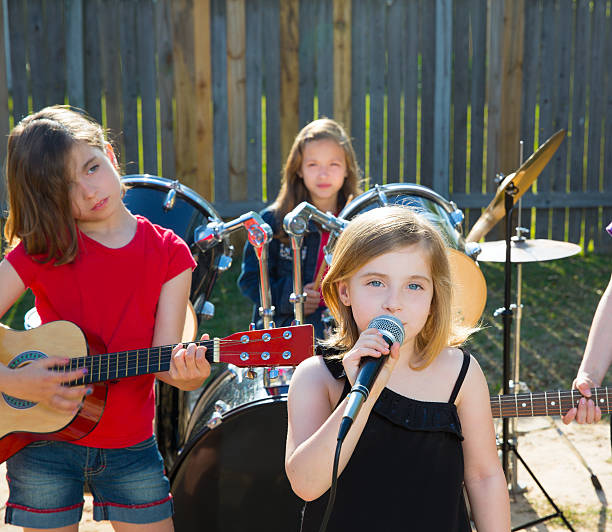 chidren cantante ragazza cantare suona musica dal vivo nel cortile - beautiful red pink wood foto e immagini stock