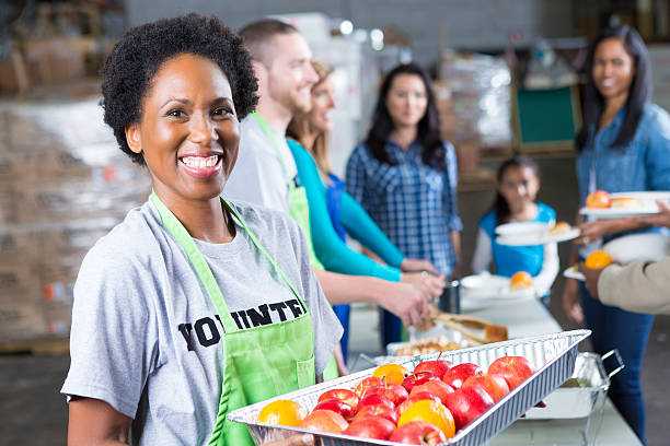 istock Friendly volunteer serving fresh fruit at community soup kitchen 483376787