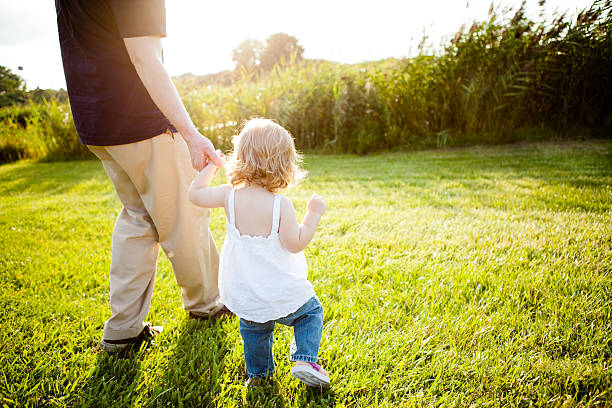 istock Daddy and Toddler Daughter Walking Outside Holding Hands 483377203