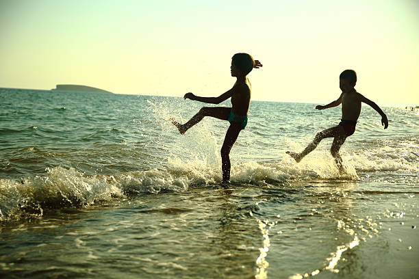 istock Little boys having fun in sea splashing 483381722
