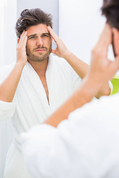 istock Reflection of man in bathrobe suffering from headache 483390123