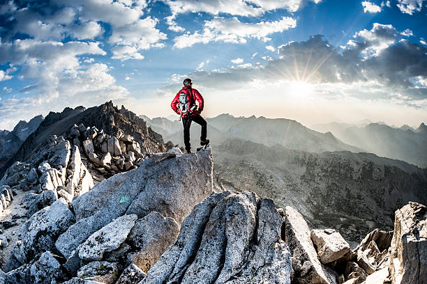 bold Mountaineer on the summit of a peak  mountain climbing stock pictures, royalty-free photos & images