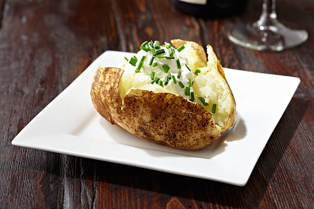 Potato Baked potato on a dark rustic wooden table. Professionally shot,  color corrected, exported 16 bit and retouched for maximum image quality. baked potato stock pictures, royalty-free photos & images