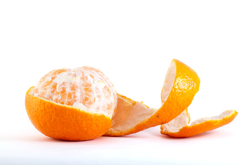 Peeled clementine, seedless variety of mandarin orange, on white background.