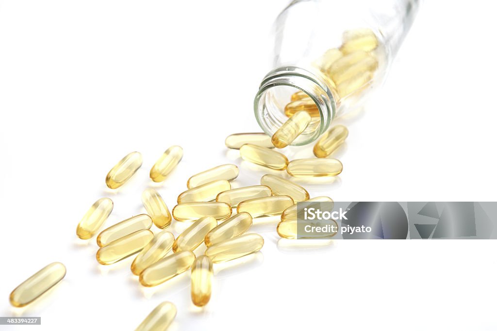 Vitamina capsule con bottiglia isolato su sfondo bianco - Foto stock royalty-free di Capsula