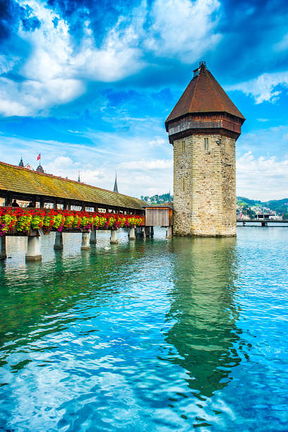 Beautiful Cityscape of old town Lucern, visible are the river Reuss waterfront of Lucerne with the famous Kapellbrucke bridge originally built in 1333, traditional swiss buildings, churches, restaurants, coffee bars, hotels, beautiful cloudscape and reflection in the water.  