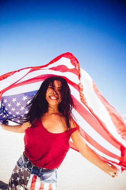 istock Woman with american flag and blue sky 483395775