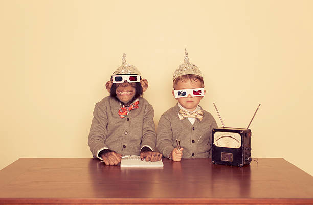 We're Listening A young boy and his chimpanzee friend are trying to communicate with higher intelligence. serious monkey stock pictures, royalty-free photos & images
